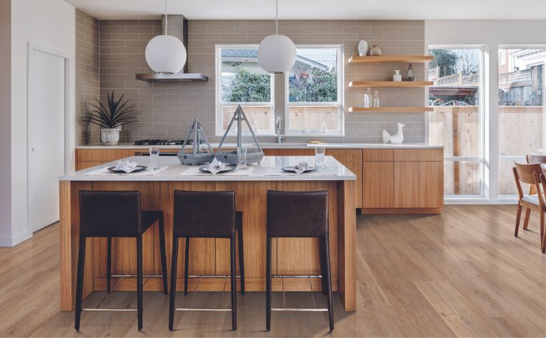 luxury vinyl in kitchen with wood details and beige subway tile backsplash